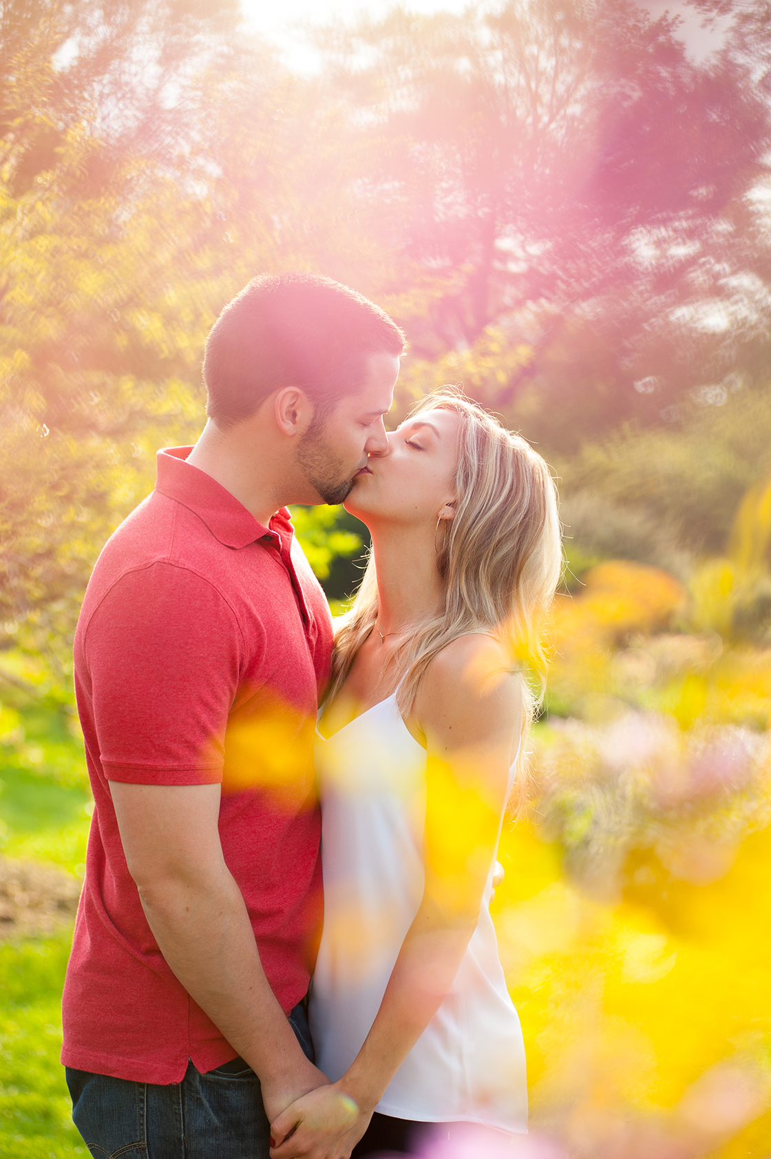 A couple kissing in glowing spring light.